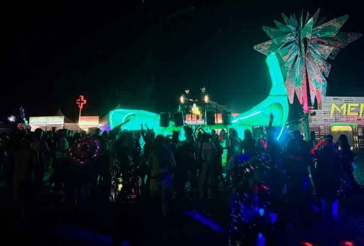 The People's Banana at Lightning in a Bottle 2025 — DJs Fleetwood Smack performing atop the glowing 30-foot banana as the crowd dances under green and pink light.
